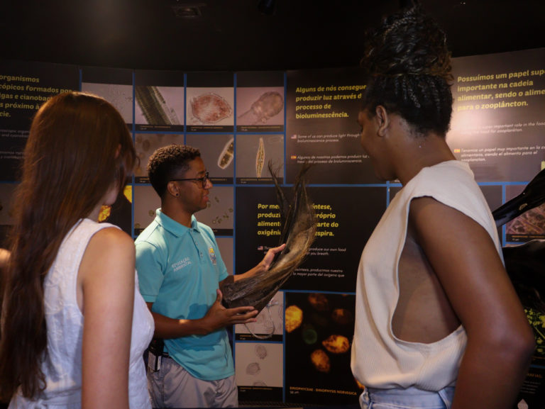 Visitantes aprendendo com educador do Aquario